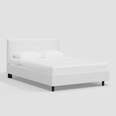 a white bed with black legs and headboard is shown in front of a gray background