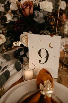 the table numbers are displayed on plates and napkins with candles in front of them