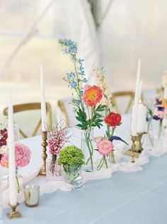 a long table with flowers and candles on it