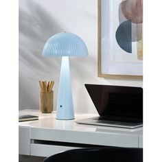 a blue lamp sitting on top of a desk next to a laptop