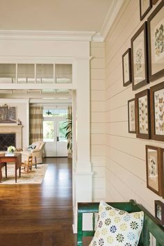 a living room filled with furniture and framed pictures on the wall next to a fire place