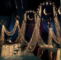 some lights that are hanging on the side of a bed with stars and moon decorations