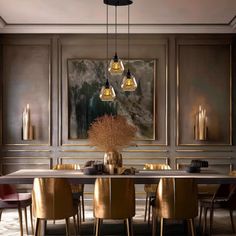 an elegant dining room with gold chairs and art work on the wall behind the table