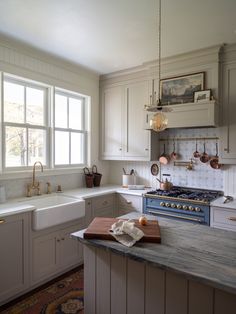 a kitchen with white cabinets and blue stove top oven