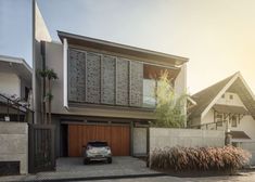 a car parked in front of a two story house with an attached garage and large windows