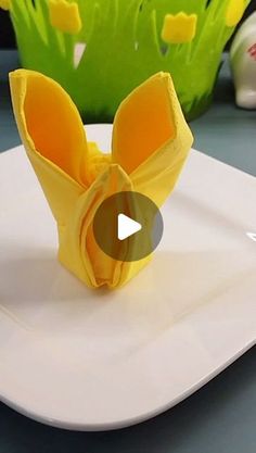 a video demonstrating how to make an origami bunny head on a white plate