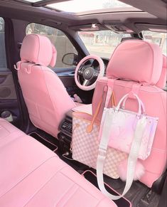 the interior of a pink car with two bags on it's back seat and one bag hanging from the front rack