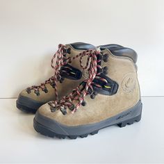 a pair of hiking boots sitting on top of a white floor