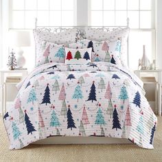 a white bed with christmas trees on it