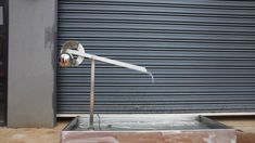 a street light sitting on top of a metal box in front of a garage door