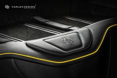 the interior of a car with black leather and yellow stitching on the seat cover