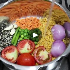 a large pot filled with lots of different types of vegetables and grains on top of a stove