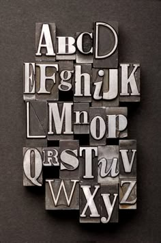 alphabets and numbers made out of metal letterpresss on a black background with clipping