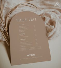 the price list is displayed on top of a white cloth with some dried grass in front of it