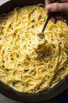 someone is stirring up some noodles in a skillet