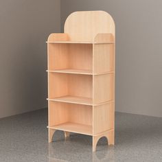 a wooden book shelf sitting on top of a floor next to a white wall and gray walls