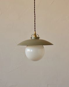 a white light hanging from a ceiling with a brown cord attached to the end of it