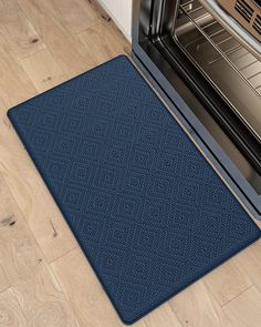 an oven door mat is shown in front of an open stove and wood flooring