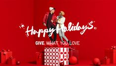 a man and woman standing next to each other in front of presents on a red background