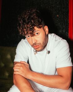 a man with curly hair sitting on a couch