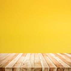 an empty wooden table against a yellow background with copy - space for text or image