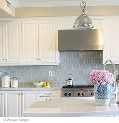 a kitchen with white cabinets and an island