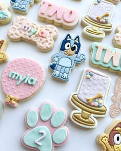 some decorated cookies are laying out on a white surface with the words i love you and paw prints