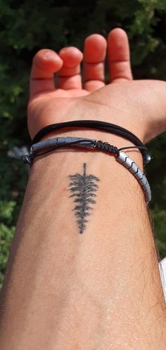 a person with a tattoo on their arm and wrist holding up his hand to the camera