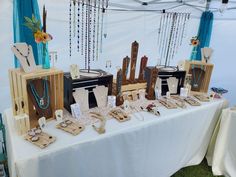 the table is set up with jewelry and necklaces on display for sale at an outdoor event