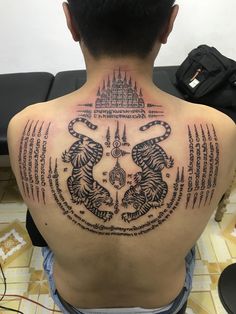 the back of a man with tattoos on his body