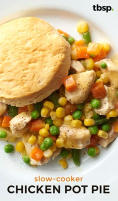 a close up of a plate of food with chicken, peas, corn and pita bread