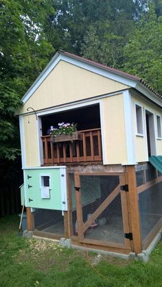 a chicken coop with a green roof and white walls