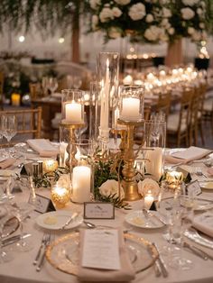 the table is set with candles, plates and place settings for an elegant wedding reception