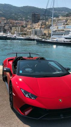 a red sports car parked next to the water