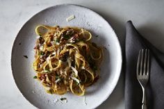 a white plate topped with pasta covered in sauce