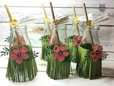 four glass vases with flowers in them sitting on a table