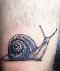 a small snail tattoo on the leg