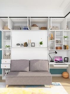 a couch sitting in front of a white book shelf filled with books and other items