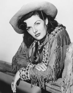 black and white photograph of a woman wearing a cowboy hat with her hand on her hip