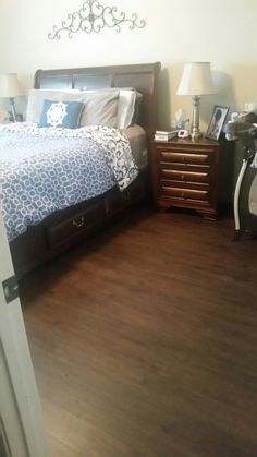 a bedroom with hardwood floors and white walls