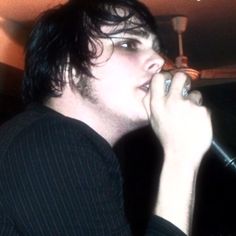 a young man is singing into a microphone