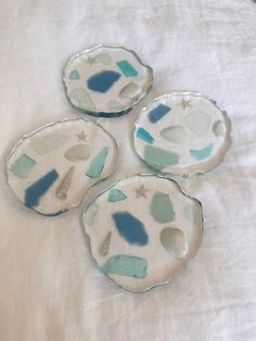 three blue and white plates sitting on top of a bed