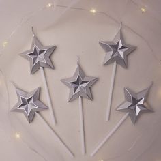 five silver stars on top of white sticks