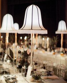 the table is set up with white linens and place settings for an elegant dinner