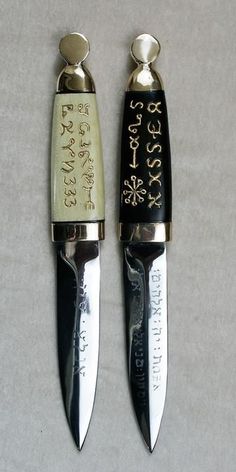 two knives with writing on them sitting next to each other