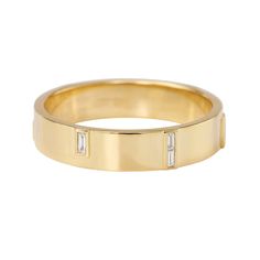 a yellow gold band with three baguets on the side and two diamonds in the middle