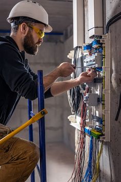 a man is working on an electrical panel