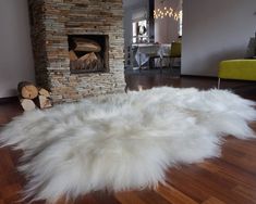 a white sheepskin rug in front of a fireplace