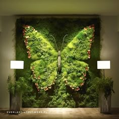 a green wall with a butterfly on it and two lamps in front of the wall