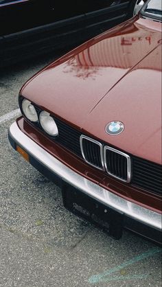 the front end of a red car parked in a parking lot